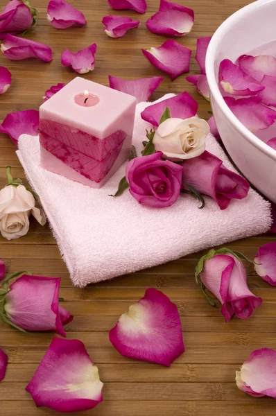 Friss, világos rózsaszín rózsa, szirmok, gyertya és egy fürdőben törölköző — Stock Fotó