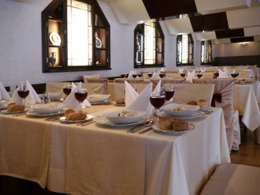 Laid tables with red wine in restaurant clipart