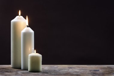 Three Candles against Dark Background clipart