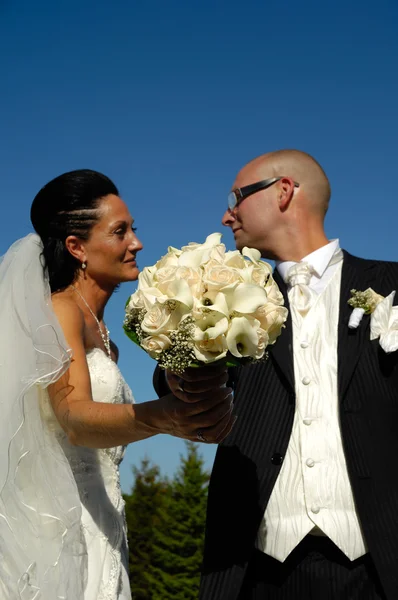 Svatební kytice a svatební pár — Stock fotografie