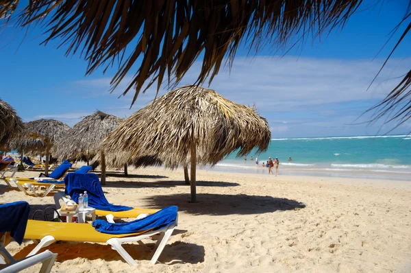 Strand med parasoller och solsängar — Stockfoto