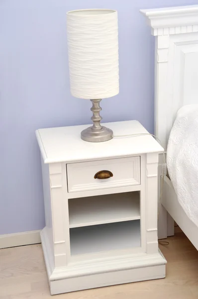 Прикроватный столик с лампой — стоковое фото