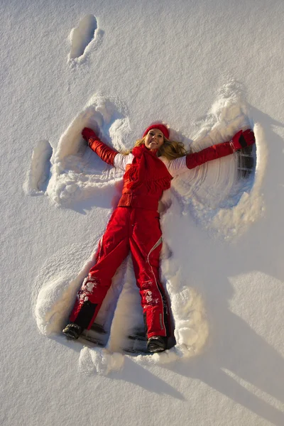 Mulher fazendo um anjo na neve — Fotografia de Stock