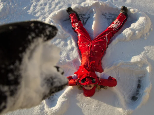Frau liegt auf Schnee und verdeckt Gesicht vor Schneefall Stockbild