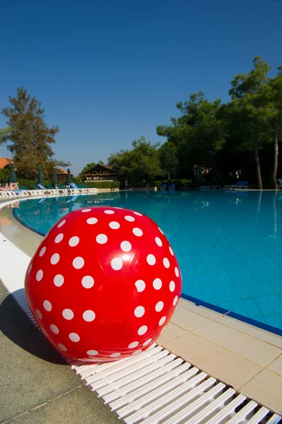 Röd badboll vid pool — Stockfoto
