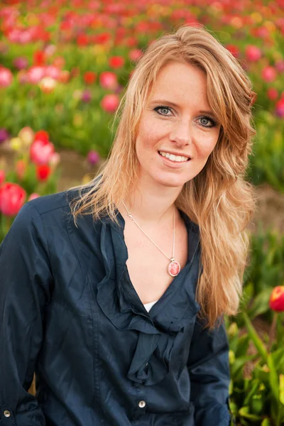 Holandés rubia chica en el campo con tulipanes —  Fotos de Stock