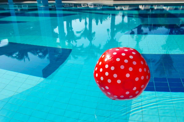 Röd prickig badboll i poolen — Stockfoto