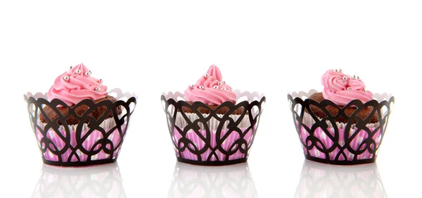 Drie chocolade cupcakes met roze boter suikerglazuur — Stockfoto