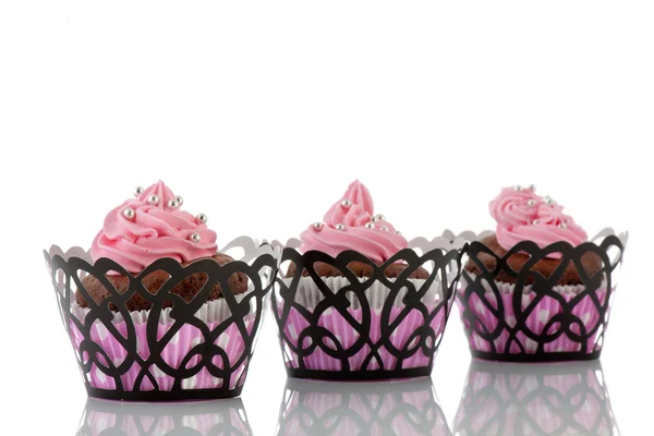 Tres cupcakes de chocolate con glaseado de mantequilla rosa Fotos de stock libres de derechos