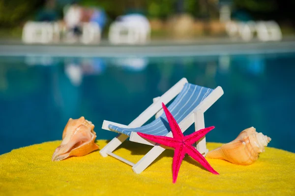 Пляжний стілець і мушлі в басейні — стокове фото