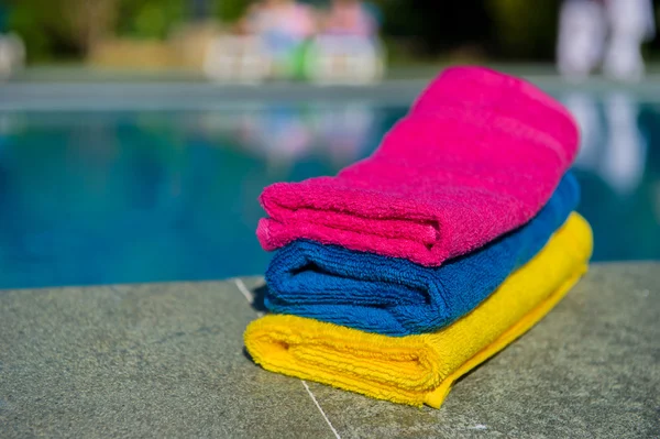 Colorful towels near swimming pool — Stock Photo, Image