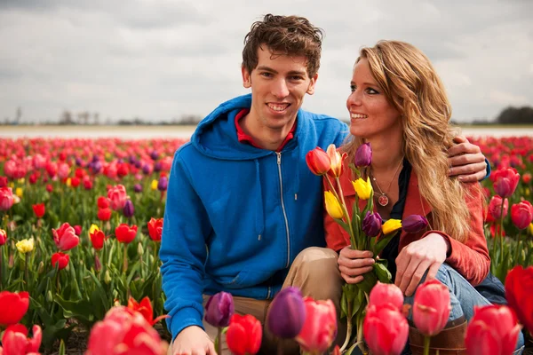 Νεαρό ζευγάρι στην ολλανδική λουλούδι πεδία — Φωτογραφία Αρχείου
