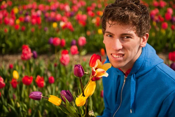 Młody człowiek jest zbieranie kwiaty — Zdjęcie stockowe