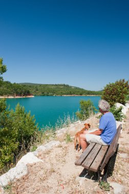 Fransız manzara içinde oturan köpekli adam