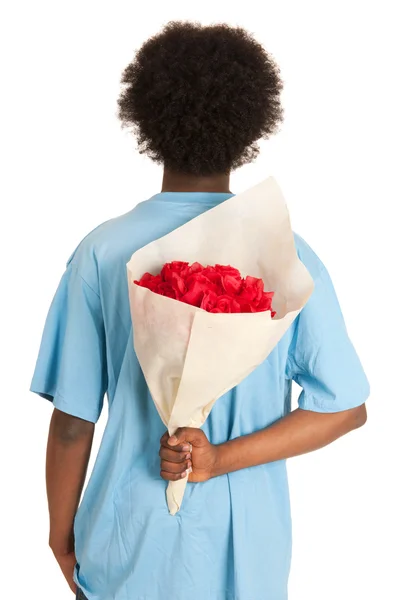 Preto teen menino está escondendo rosas — Fotografia de Stock