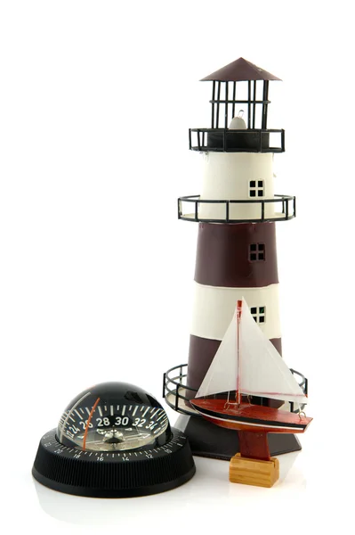 Lighthouse compass and sail boat — Stock Photo, Image