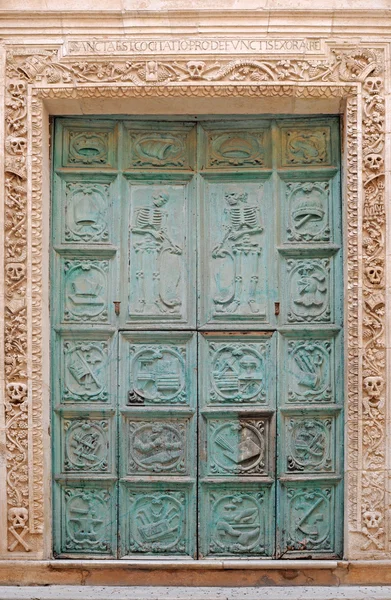 Антикварная дверь украшена черепами и скелетами — стоковое фото