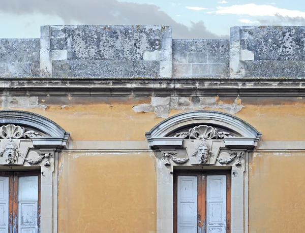 Antieke gable met stenen gezichten in brindisi, Italië — Stockfoto