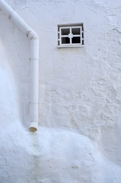 Маленькое окно и водосточная труба — стоковое фото