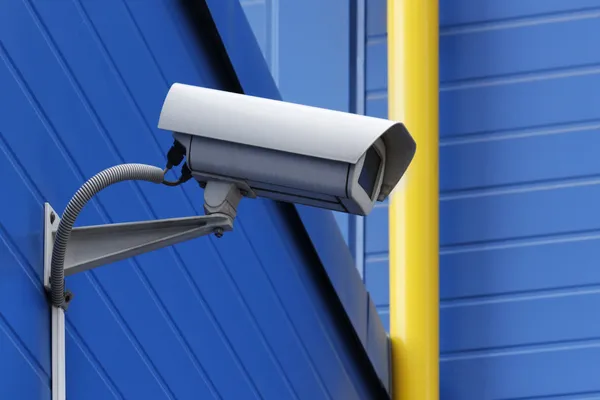 Câmera de vigilância ao lado de tubo amarelo — Fotografia de Stock