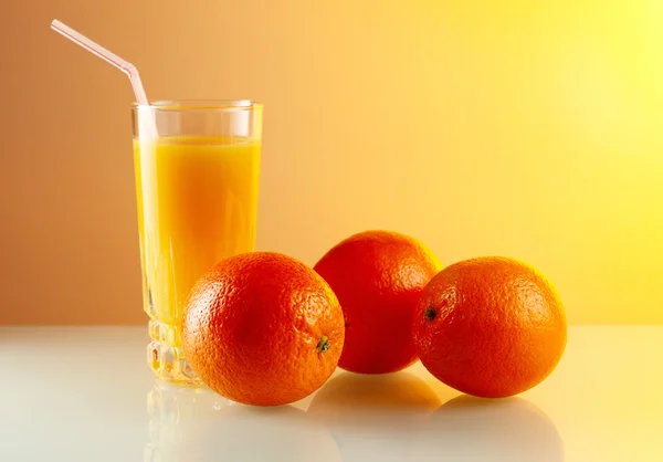 Πορτοκάλια και ποτήρι με χυμό. — Φωτογραφία Αρχείου