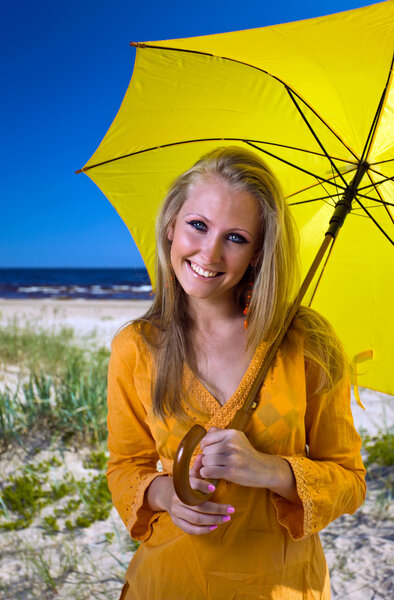 Woman with umbrella on a beach.