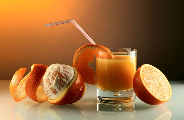 Orangen und Glas mit Saft. — Stockfoto