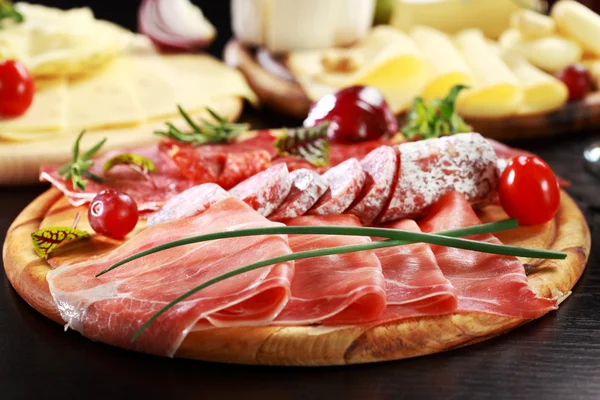 Salami and cheese platter with herbs — Stock Photo, Image