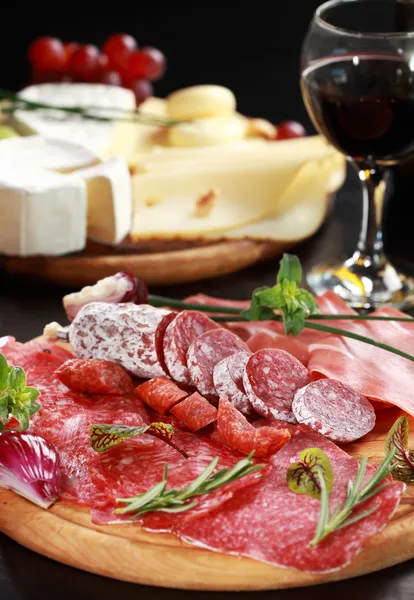 Salami and cheese platter with herbs — Stock Photo, Image
