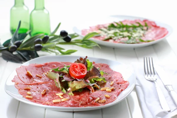Carpaccio mit Salat und Pinienkernen — Stockfoto