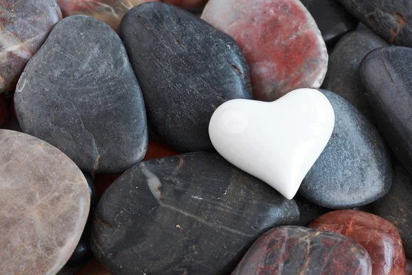 Bílé srdce obklopené kameny — Stock fotografie
