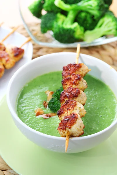 Broccoli soup with skewered chicken — Stock Photo, Image