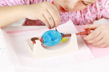 Child painting Easter eggs