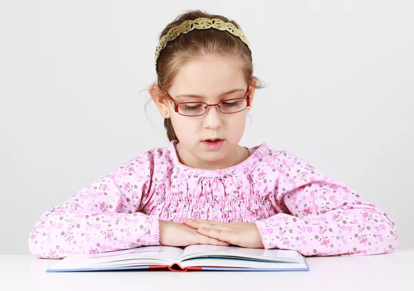 Schoolgirl with glasses reading book — Stock Photo, Image