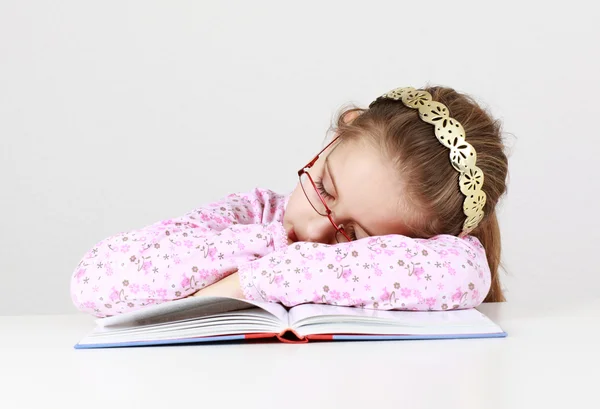 Уставшая школьница спит на книгах — стоковое фото