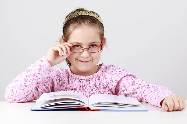 Školačka s brýlemi čtení knihy — Stock fotografie