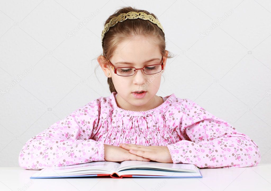 Schoolgirl with glasses reading book