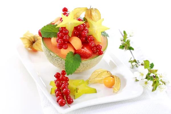 Fresh fruits served in melon bowl — Stock Photo, Image