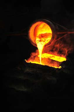 Foundry - molten metal poured from ladle into mould - emptying leftover clipart