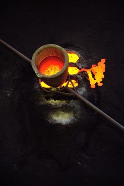 Foundry - molten metal in crucible standing on moulds - leftover clipart