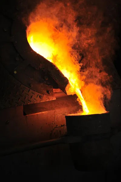 Литейное производство - расплавленный металл, выливаемый из ковша для литья — стоковое фото