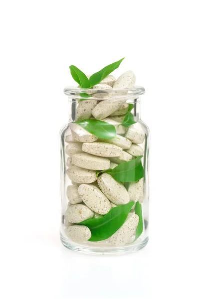 Kräuterergänzungspillen und frische Blätter im Glas - alternative Medizin — Stockfoto