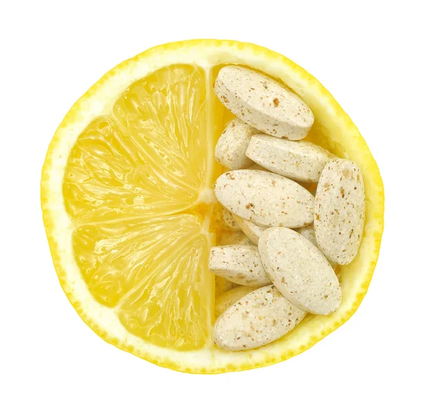 Nahaufnahme von Zitrone und Pillen isoliert - Vitamin-Konzept lizenzfreie Stockfotos