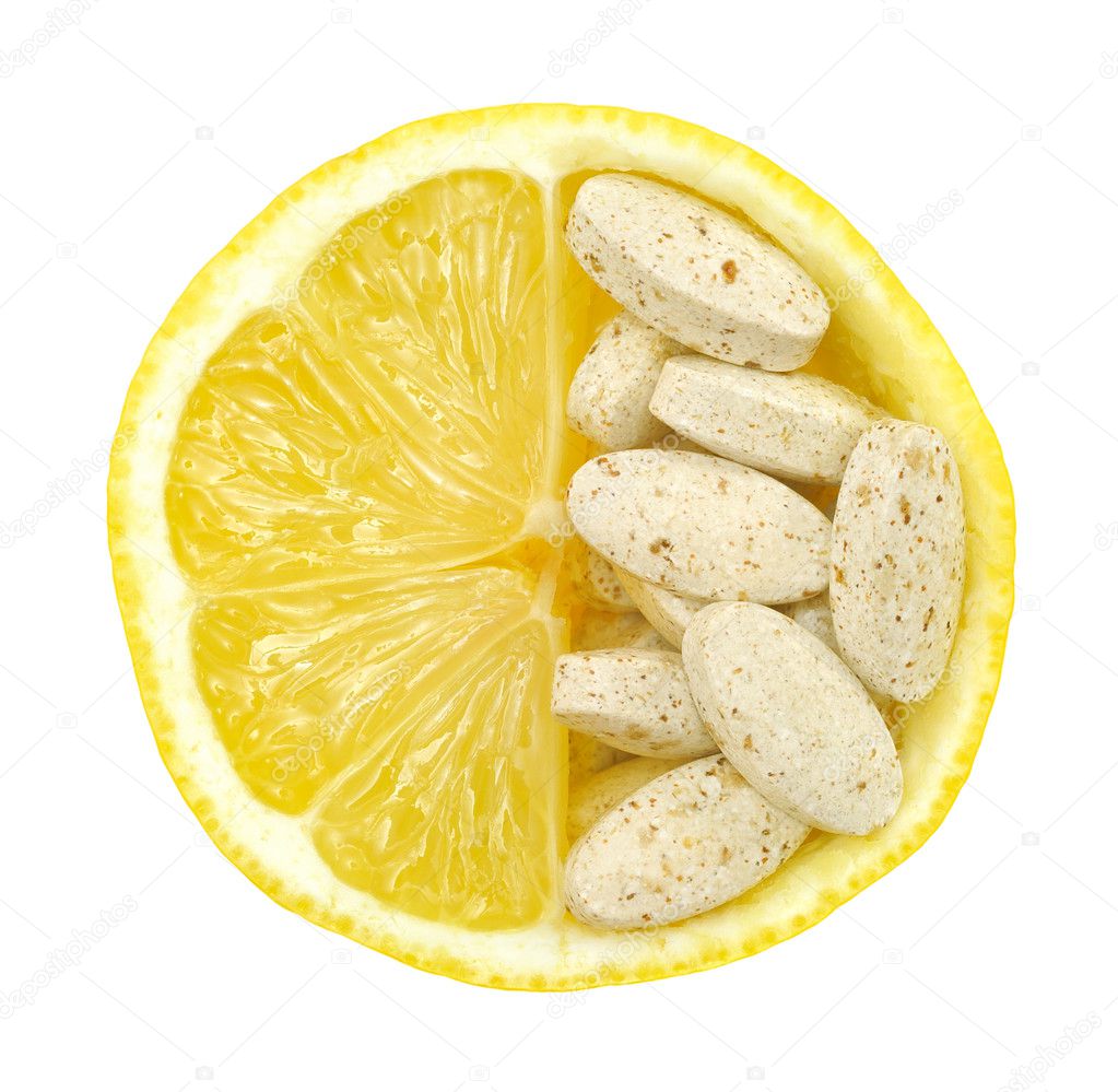 Close up of lemon and pills isolated – vitamin concept