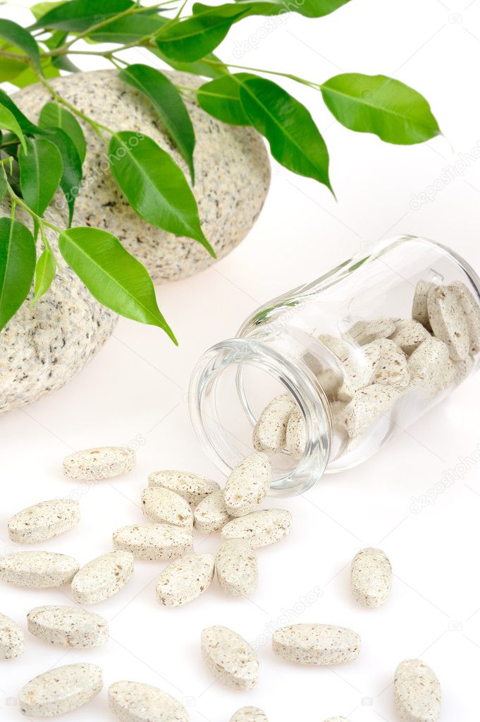 Herbal supplement pills spilling out of bottle – alternative medicine conce