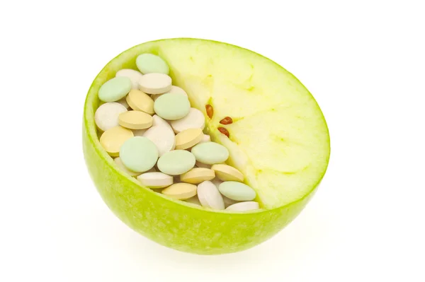Gros plan sur les pommes et les pilules isolées - concept de vitamine — Photo