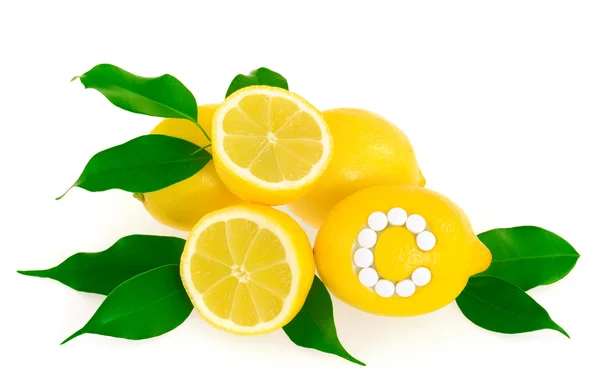 Limones con píldoras de vitamina C sobre fondo blanco concepto — Foto de Stock