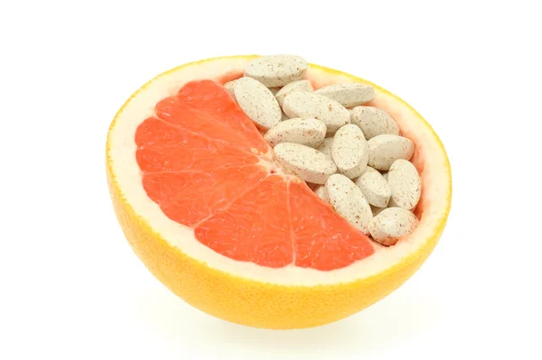 Close up van rode grapefruit en pillen geïsoleerd - vitamine concept — Stockfoto