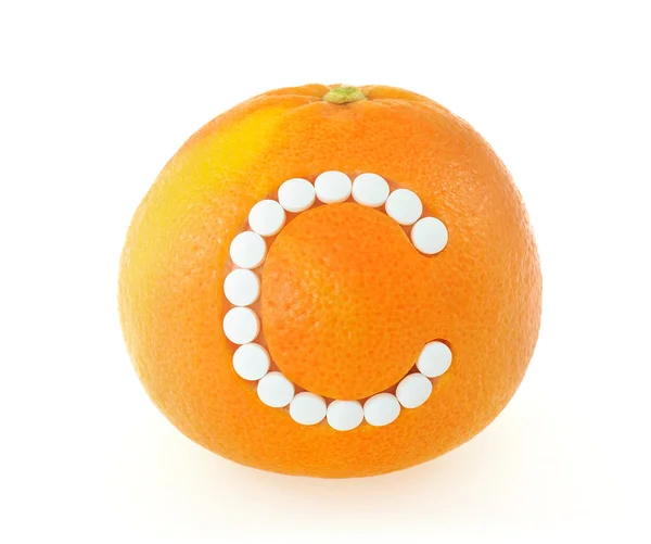 Pomelo con píldoras de vitamina C sobre fondo blanco - concepto — Foto de Stock