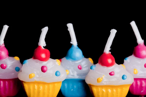 Cup cake candles close up on black background — Stock Photo, Image